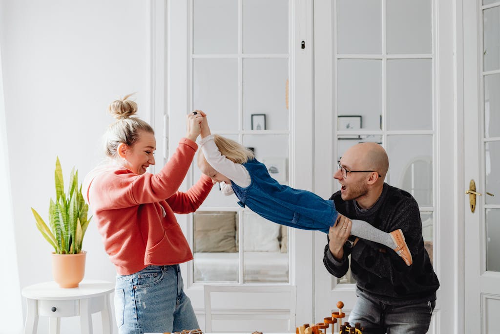 A joyful family moment with parents playing with their daughter indoors. March Break fun.