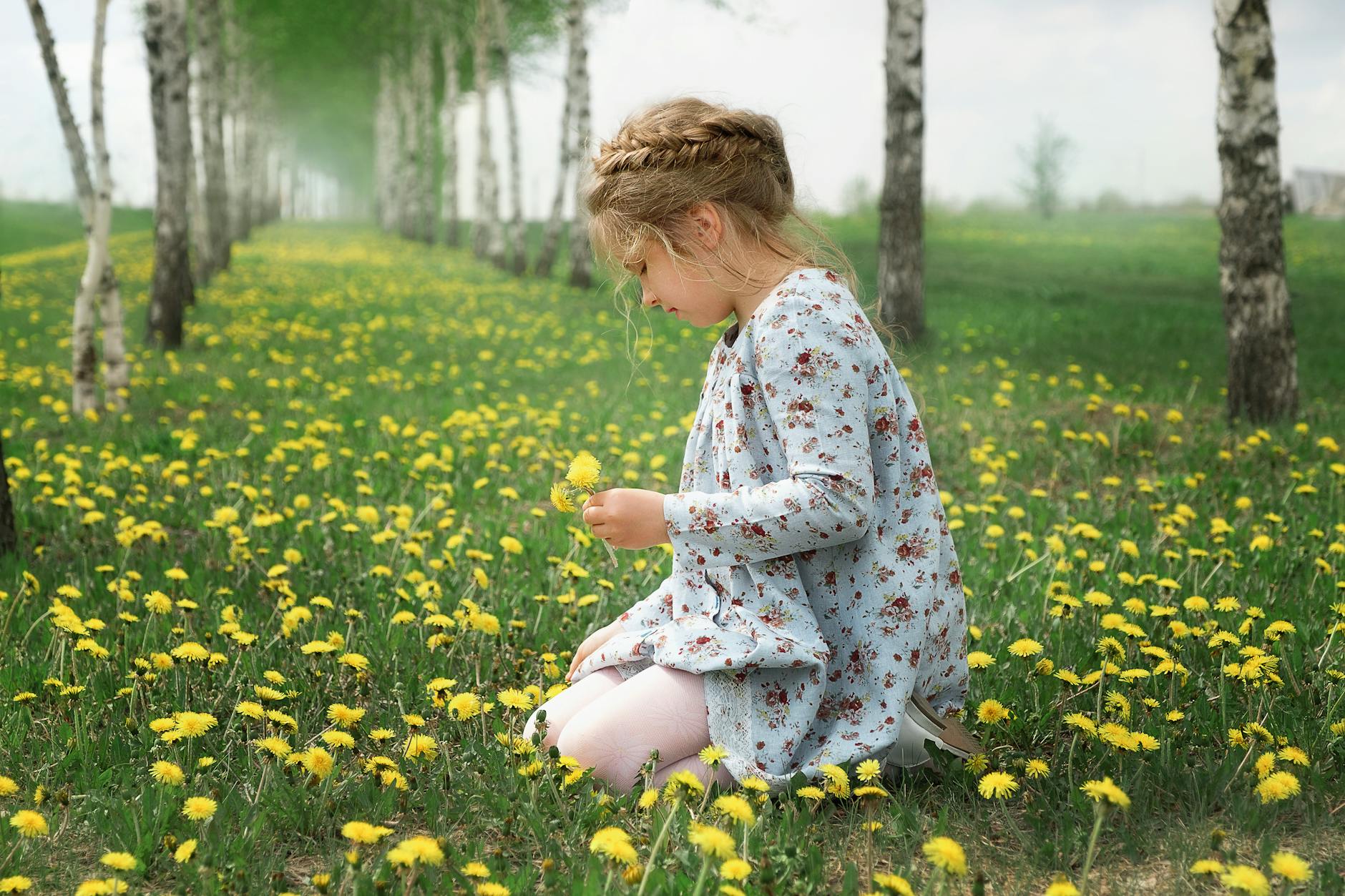 child wearing floral dress picking flowers