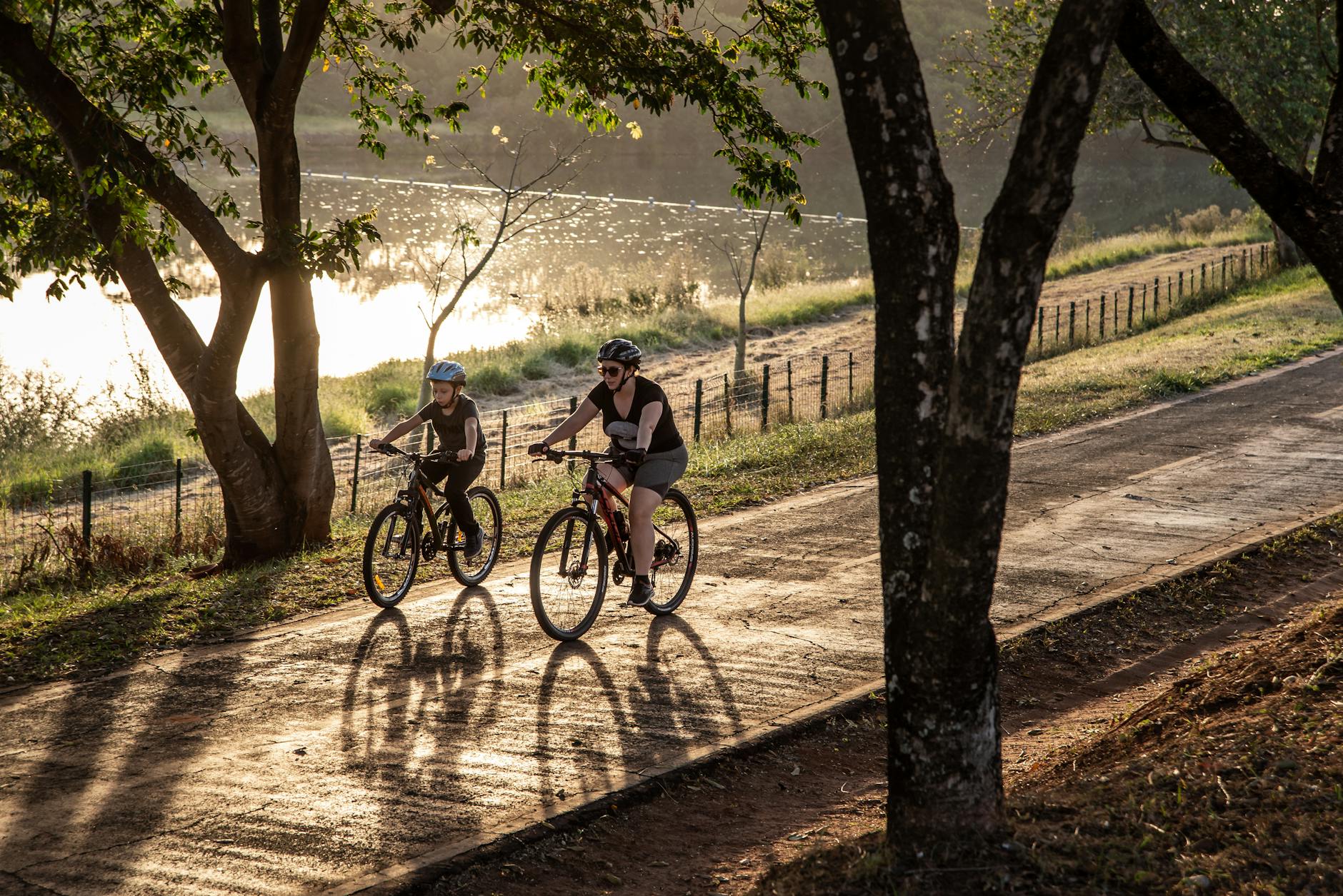 a boy and woman riding bicycles on the road