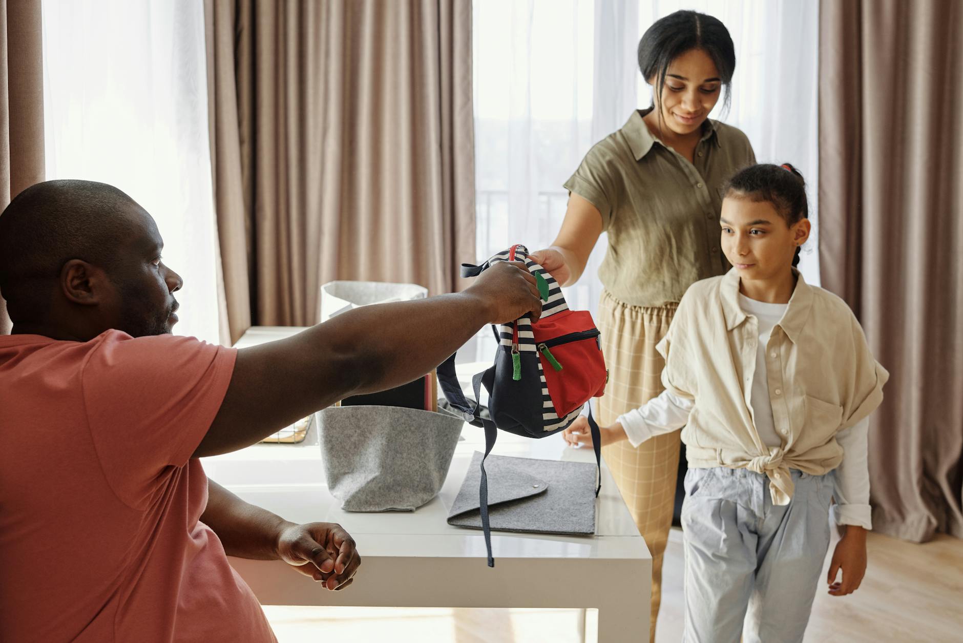 parents helping their daughter to get ready for school