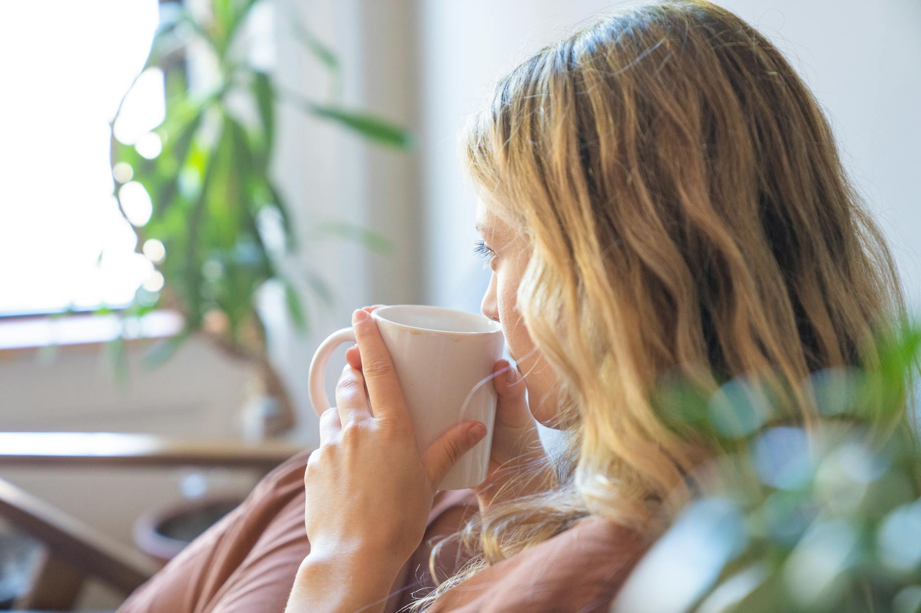 close up of a blonde woman drinking coffee